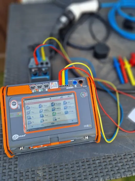 Installationstester mit Prüfleitungen bei der Messung an einem Ladepunkt für Elektroautos